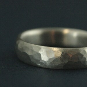 May include: A silver hammered wedding band with a textured finish.
