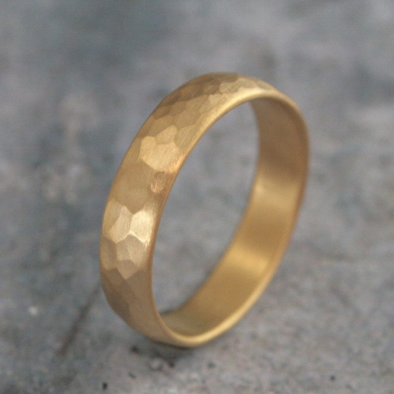 May include: A gold hammered wedding band with a smooth, polished interior.
