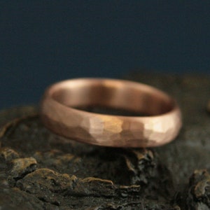 May include: A hammered copper wedding band with a rounded profile.