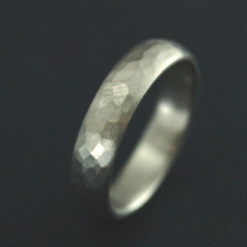 May include: A silver hammered wedding band.