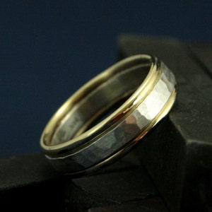 May include: A hammered silver band with a thin gold band on each side. The ring is made of two different metals.