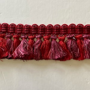 A Collection of fine European Fringe by the yard in Burgundy Variegate 2-1/2&quot; tassel fringe size. Available in a Min. 4-yard increment only.