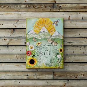 Könnte beinhalten: Ein Holz-Kopfteil mit einem geflochtenen Rattan-Design, einem grünen Bettbezug und verschiedenen Kissen. Ein gerahmtes Bild mit einer Naturszene und dem Text "All good things are wild and free" hängt an der Wand über dem Kopfteil. Eine Hängeleuchte aus Weidengeflecht hängt von der Decke über einem Holz-Nachttisch mit einer Vase mit Trockenblumen.