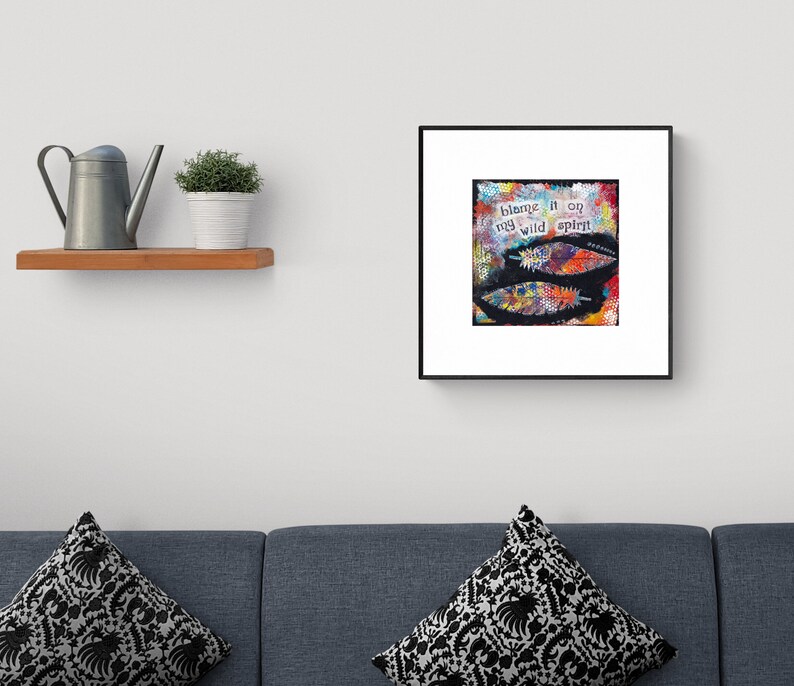 Puede incluir: Una impresi&oacute;n de arte enmarcada con fondo negro y plumas de colores. El texto en la impresi&oacute;n dice "blame it on my wild spirit."