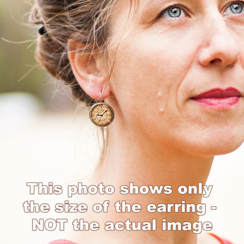 May include: A pair of gold-toned earrings with a round, clock-face design. The earrings are small and delicate.