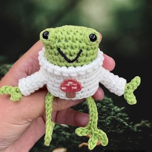 Crochet frog in jumper with a  mushroom motif: pocket frog emotional support desk buddy