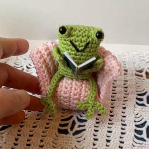 Crochet frog sitting in an armchair reading a book, shelf decor, desk buddy