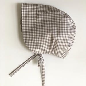 Puede incluir: Un juego de tres tazas de cerámica con acabado mate moteado. Las tazas son de color crema, gris claro y gris oscuro. Cada taza tiene un diseño simple y minimalista.