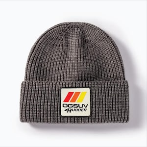 May include: A gray ribbed knit beanie with a rectangular patch. The patch features the text "OGSUV 4Runner" in white, with red, orange, and yellow stripes above the text. The beanie is a winter accessory.