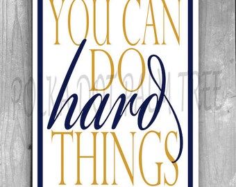 May include: A square print with a white background and a navy blue border. The text "YOU CAN DO hard THINGS" is displayed in gold and navy blue, with a handwritten font for "hard".