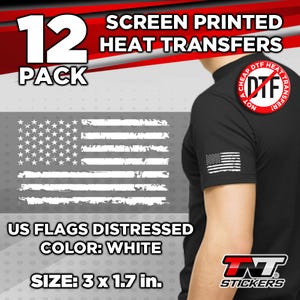 Puede incluir: Un paquete de 12 transferencias de calor de banderas estadounidenses blancas desgastadas, cada una mide 7,62 cm por 4,32 cm. La imagen muestra una camiseta negra con una transferencia de calor de bandera estadounidense blanca desgastada en la manga. El texto "NOT A CHEAP DTF HEAT TRANSFER" está impreso en un círculo rojo en la parte posterior de la camiseta.