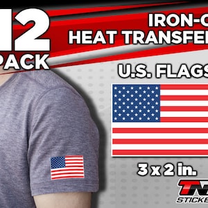 May include: A pack of 12 iron-on heat transfers featuring the American flag. Each transfer is 3 inches by 2 inches. The image shows a grey t-shirt with a transfer on the sleeve. The text "IRON-ON HEAT TRANSFERS" and "U.S. FLAGS" is also visible.