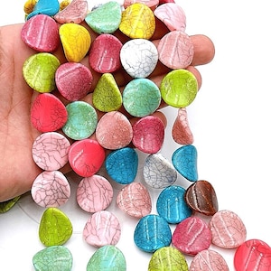 以下が含まれることがあります： ひび割れた仕上げのカラフルな丸い平らなビーズのストランド。ビーズはピンク、グリーン、ブルー、イエロー、ブラウンの色合いです。