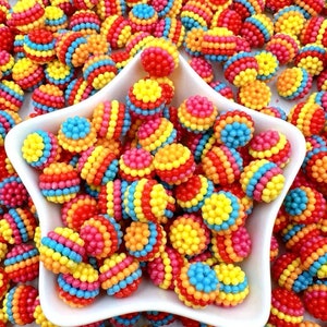 May include: A bowl filled with colourful beads. The beads are round and have a striped pattern of red, yellow, orange, and blue.