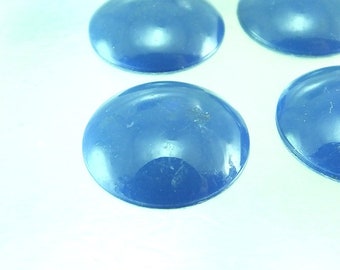 Puede incluir: Cuatro cabujones redondos y lisos, de color azul, probablemente de vidrio o cerámica, están dispuestos sobre una superficie blanca. Los cabujones son ligeramente abovedados y tienen un acabado brillante.