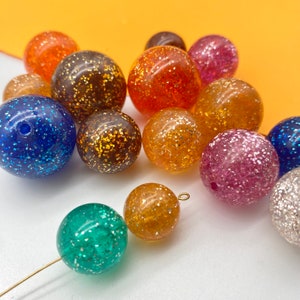 Puede incluir: Surtido de cuentas redondas y brillantes en varios colores, incluyendo azul, verde, rosa, naranja y dorado. Las cuentas tienen un di&aacute;metro aproximado de 2,5 cm.