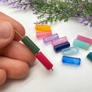 May include: Assortment of colorful, translucent, cylindrical beads. The beads are made of glass or plastic and are strung on a gold wire. The beads are in various colors, including red, green, blue, yellow, pink, and light blue.