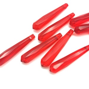 May include: A group of ten red faceted glass teardrop beads. The beads are approximately 1.5 inches long and have a pointed tip.