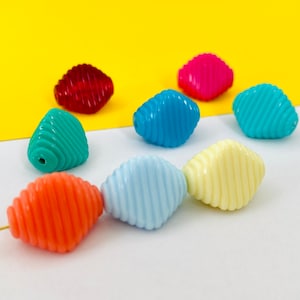 Pode incluir: Conjunto de contas de plástico coloridas com um design de espiral. As contas são em tons de azul, verde, rosa, vermelho, laranja e amarelo.