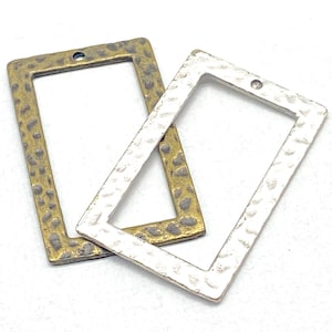 May include: Two rectangular metal jewelry pendants. One is gold-toned with a hammered texture, the other is silver-toned with a similar hammered texture. Both have a small hole at the top for stringing.