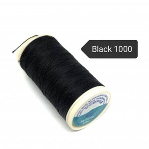 May include: A spool of black thread labeled "Black 1000". The thread is tightly wound around a white and blue spool. The thread is a deep black color, and the spool has a white rim.