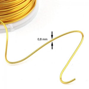 Può includere: Un rotolo di filo color oro con un primo piano del filo che mostra un diametro di 0,8 mm.