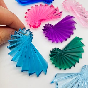 Peut inclure: Six ornements en spirale en acrylique de couleurs bleu, rose, violet, vert et bleu clair. Les ornements sont en forme de spirale et ont un design en éventail.