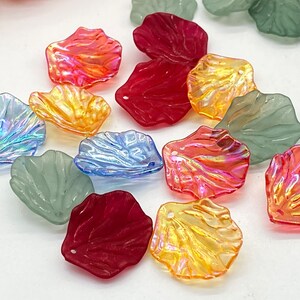 May include: Assortment of iridescent plastic flower petals in various colours, including red, orange, yellow, blue, and green. The petals have a textured surface and are ideal for crafting projects.