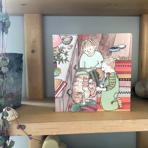 Pu&ograve; includere: Un'illustrazione di due bambini che aiutano una gatta madre e i suoi gattini a uscire da un cassetto. La gatta madre &egrave; marrone e bianca, e i gattini sono arancioni e bianchi. I bambini indossano abiti colorati e sorridono.