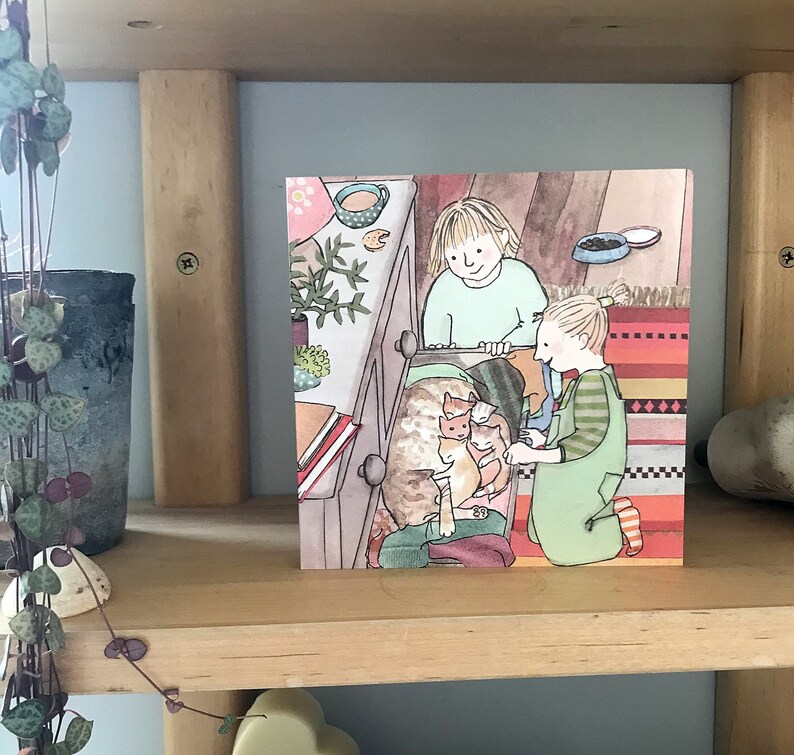 Pu&ograve; includere: Un'illustrazione di due bambini che aiutano una gatta madre e i suoi gattini a uscire da un cassetto. La gatta madre &egrave; marrone e bianca, e i gattini sono arancioni e bianchi. I bambini indossano abiti colorati e sorridono.