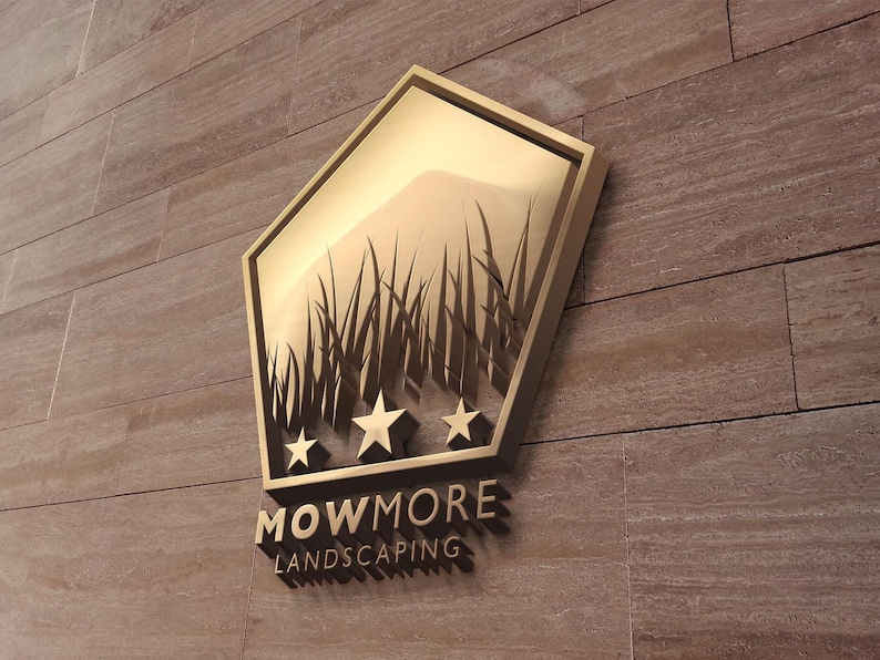 A gold pentagonal logo with grass and three stars, and the text "MOWMORE LANDSCAPING" in raised letters, mounted on a textured brown wall.