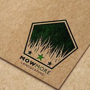 A pentagonal logo with green grass, three green stars, and "MOWMORE LANDSCAPING" text printed on a brown paper background.
