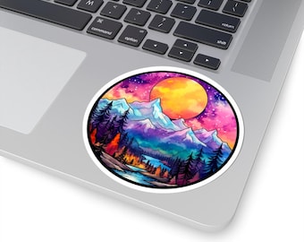 May include: A round sticker featuring a vibrant watercolor landscape. The design includes purple mountains, a large orange sun, and a colorful sky with pink and purple hues. The sticker is placed on a laptop.