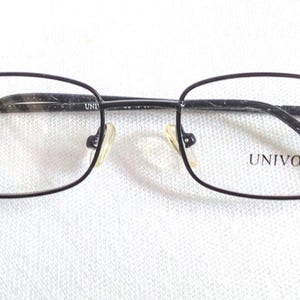 May include: Black rectangular eyeglasses with the brand name "UNIVO" printed on the right lens. The frames are a dark color, and the lenses are clear. The glasses are set against a white background.