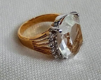 J29 Bague tendance vintage accrocheuse. Grande pierre centrale transparente avec des accents de pierre claire. Monture plaquée or. Livraison internationale gratuite