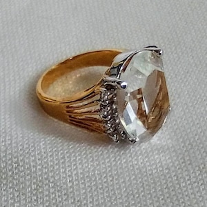 J29 Bague auriculaire tendance vintage accrocheuse (petite). Grande pierre centrale transparente avec des accents de pierre claire. Monture plaquée or. Expédition suivie