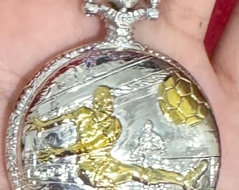 W260 Vintage zilverkleurig zakhorloge op batterijen met voetbalreliëf. Verzending met tracking.