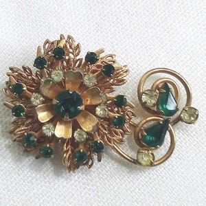 JP153. Mooie vintage goudkleurige broche uit de jaren 50. Bloementhema. Heldere en groene strassteenaccenten.