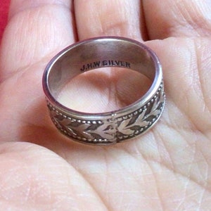 May include: Silver ring with a floral design and the inscription "J.H.W. SILVER" on the inside.