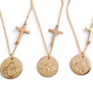 May include: Three gold necklaces with a small cross charm and a larger round pendant with engraved initials. The initials are "SC", "LRS", and "MW".