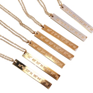 May include: Six gold necklaces with rectangular pendants featuring engraved coordinates. The coordinates are: 37&deg; 47' 68'' N 122&deg; 26' 7'' W, 32&deg; 14' 8&deg; N 37&deg; 30' 1'' W, 40&deg; 25' N 75&deg; 20' 14'' W, 32&deg; 49' 33'' N 96&deg; 44' 37'' W, 32&deg; 46' 24'' N 96&deg; 44' 37'' W, and 32&deg; 49' 33'' N 96&deg; 44' 37'' W.