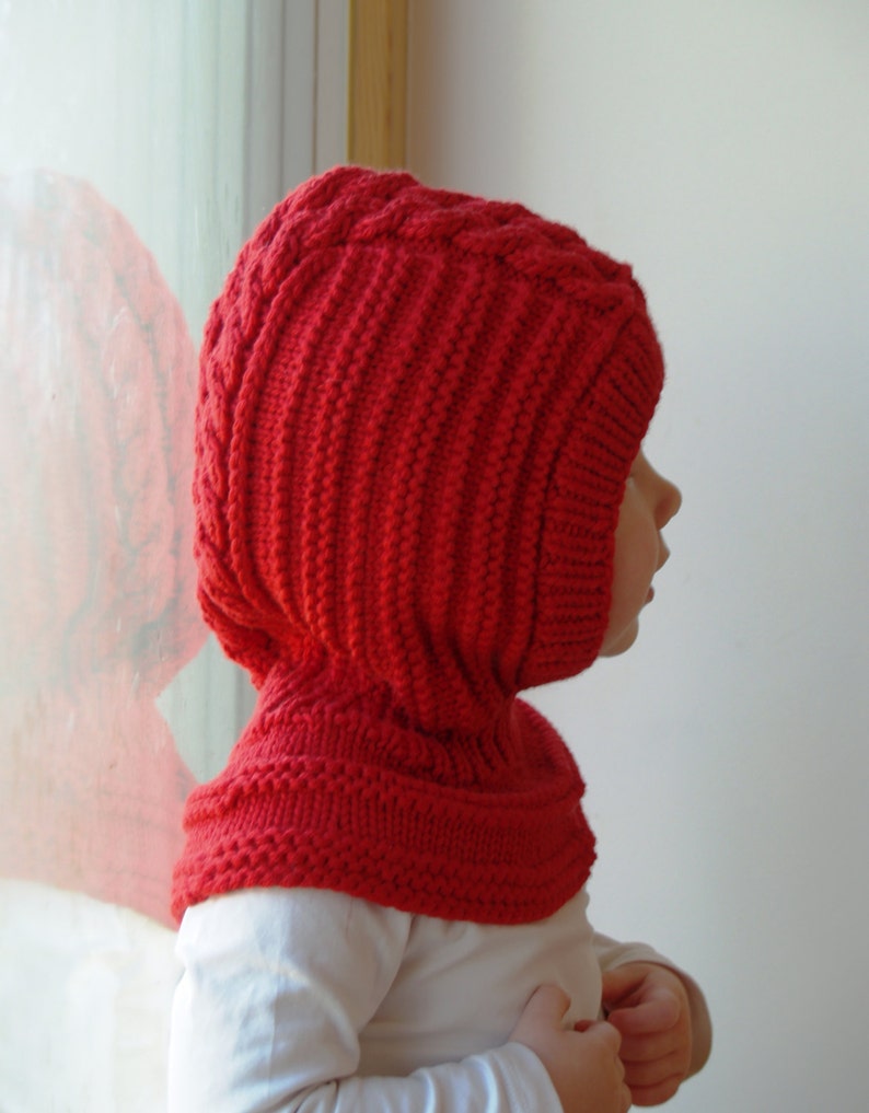Puede incluir: Un gorro y una bufanda con capucha de punto rojo para un ni&ntilde;o. El gorro tiene un patr&oacute;n de punto de cable y la bufanda es de punto simple.