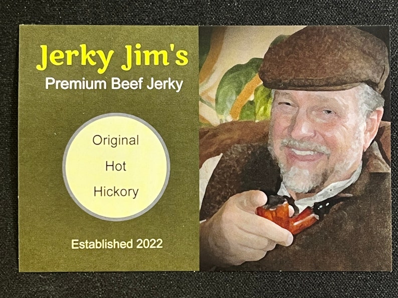 May include: A business card for Jerky Jim's Premium Beef Jerky. The card is green with yellow text. It features a circle with the words "Original", "Hot", and "Hickory" inside. The card also says "Established 2022". A man with a brown hat and beard is pictured on the right side of the card.