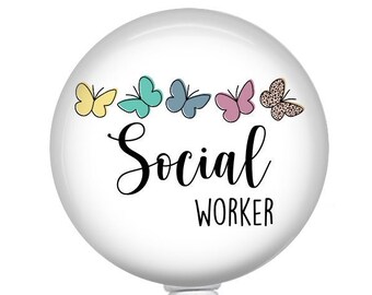 May include: White retractable badge holder with a white round button featuring a line of colorful butterflies and the text "Social Worker".