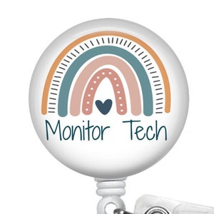 May include: White retractable badge holder with a round, white button featuring a rainbow design with a heart in the center. The text "Monitor Tech" is printed below the rainbow.