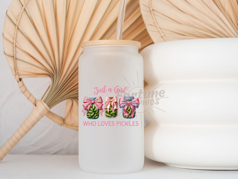 Op de afbeelding: Een witte, gematteerde glazen beker met een bamboe deksel en een rietje. De beker heeft een roze afbeelding van drie augurkenpotten met roze strikken en de tekst "Just a Girl Who Loves Pickles".