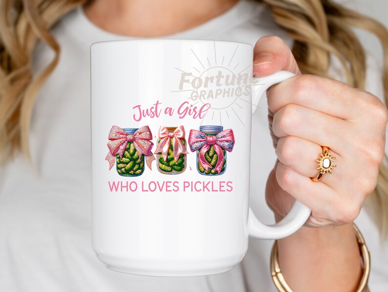 Op de afbeelding: Een witte keramische mok met een roze en groene illustratie van drie potten met augurken met roze strikken. De tekst "Just a Girl Who Loves Pickles" staat op de mok gedrukt.