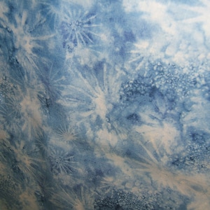 May include: Blue fabric with a white and blue tie-dye pattern. The pattern resembles snowflakes or stars.