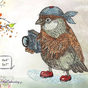 May include: A brown and gray sparrow wearing a blue bandana and red shoes holds a black camera. The sparrow is looking at something off to the left of the image. The background is a light beige with a few brown and orange leaves scattered around.