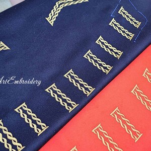 May include: Two fabric swatches with gold embroidery of the Roman numeral "II" repeated across the fabric. The top swatch is navy blue and the bottom swatch is red.